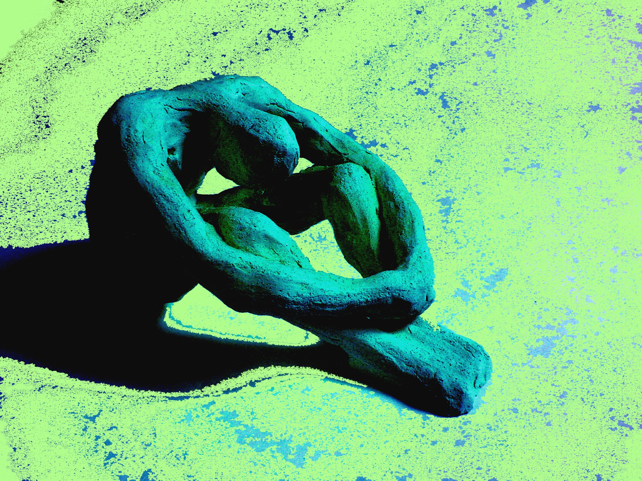 A sculpture of a hand holding a chain link, set against a textured green background.