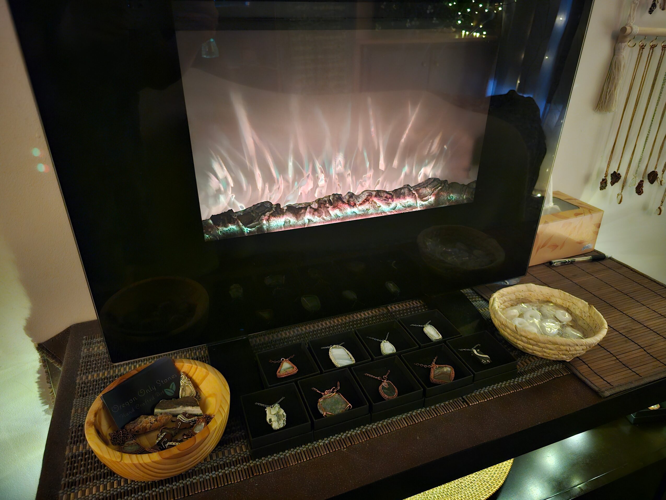 Electric fireplace with decorative logs, two bowls with snacks or food, and a row of small containers on a table.