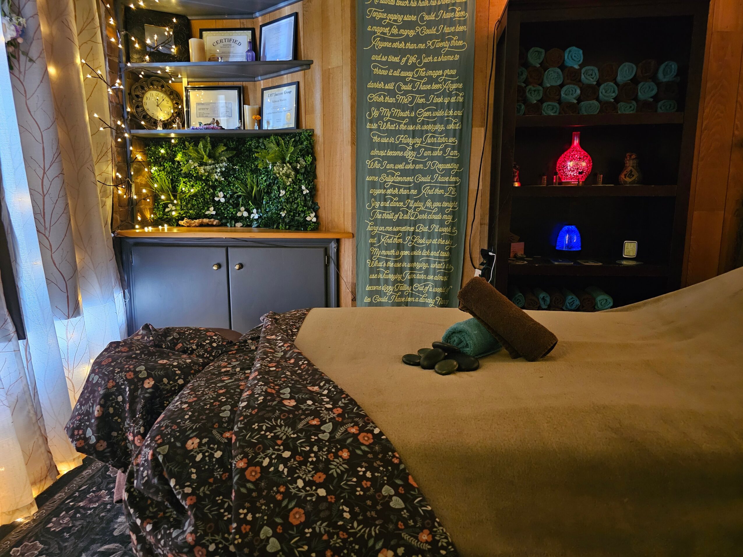 Cozy room with bed, shelves, and decorative lights, featuring books, plants, and colorful lamps, with a window on the left.