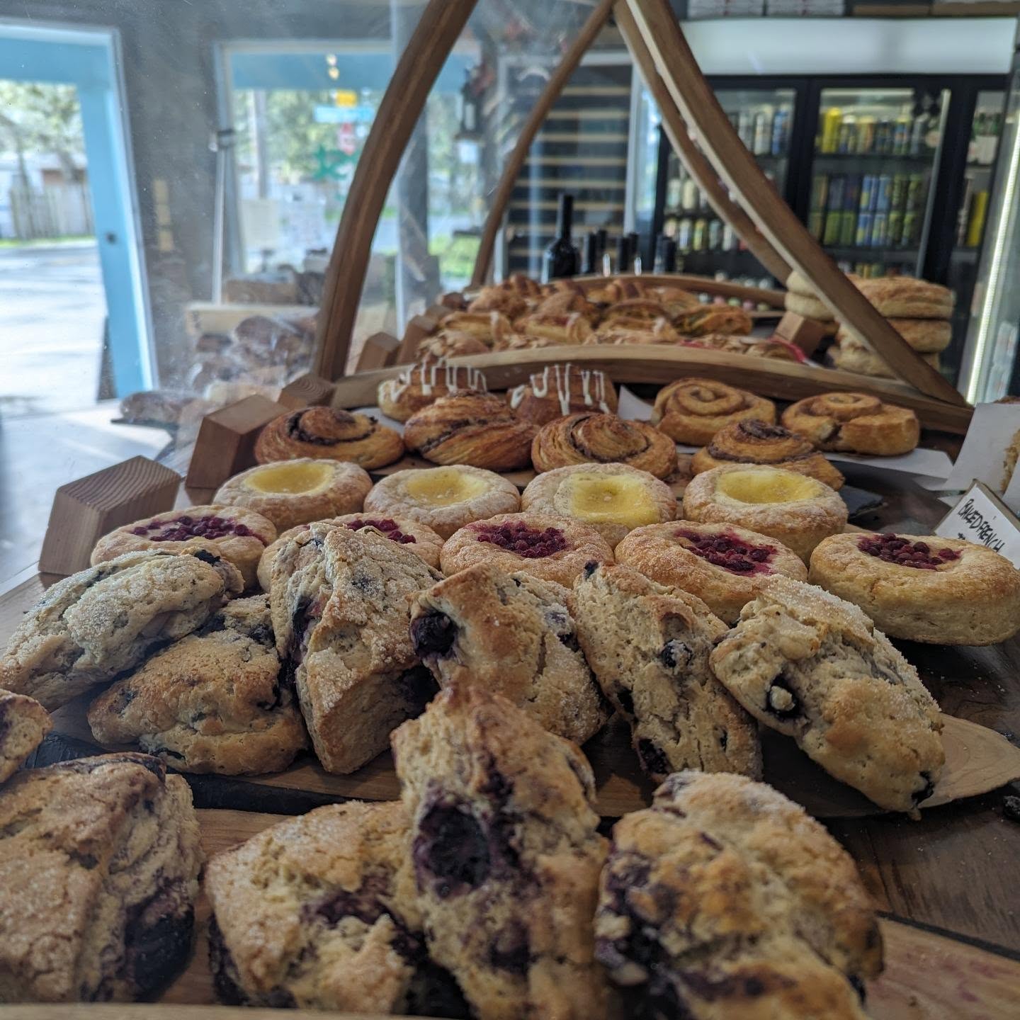 Assorted baked goods including cookies, tarts, and pastries displayed on a table inside a bakery or cafe.