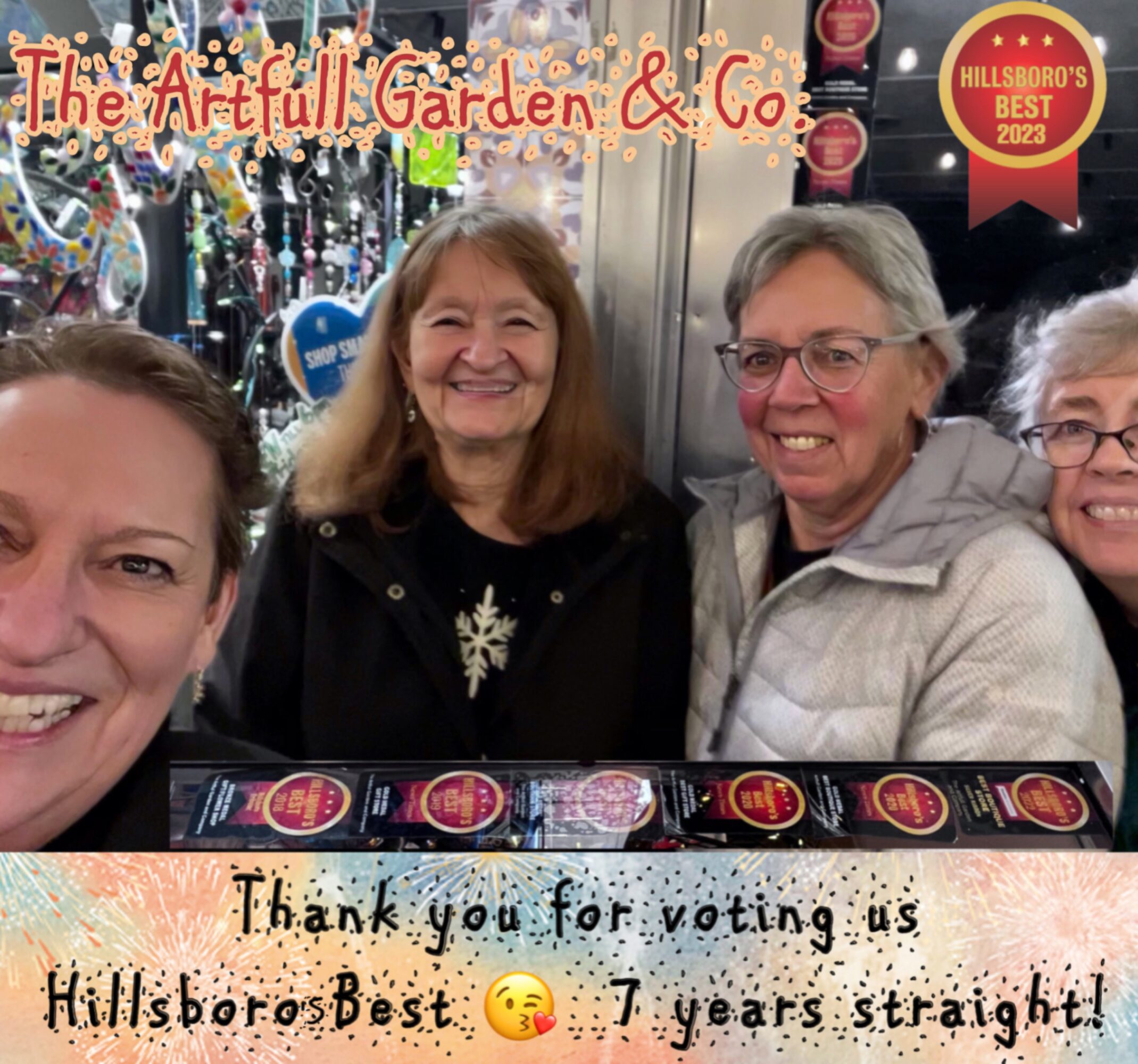 Four women smiling at a booth with colorful decorations, celebrating Hillsborough's Best award, thanking voters after seven years.