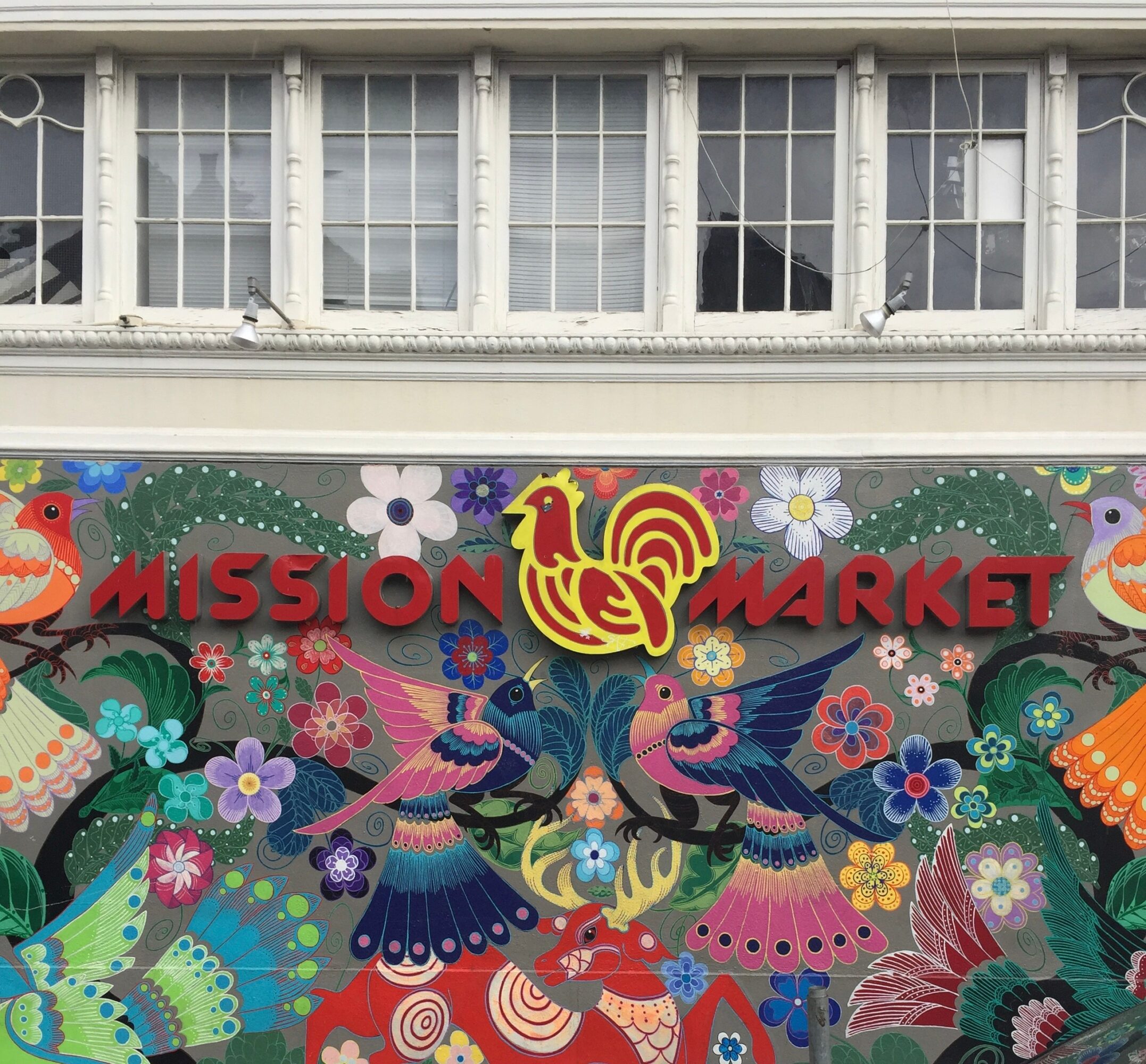 Colorful mural with birds, flowers, and the words 'MISSION MARKET' in red letters.