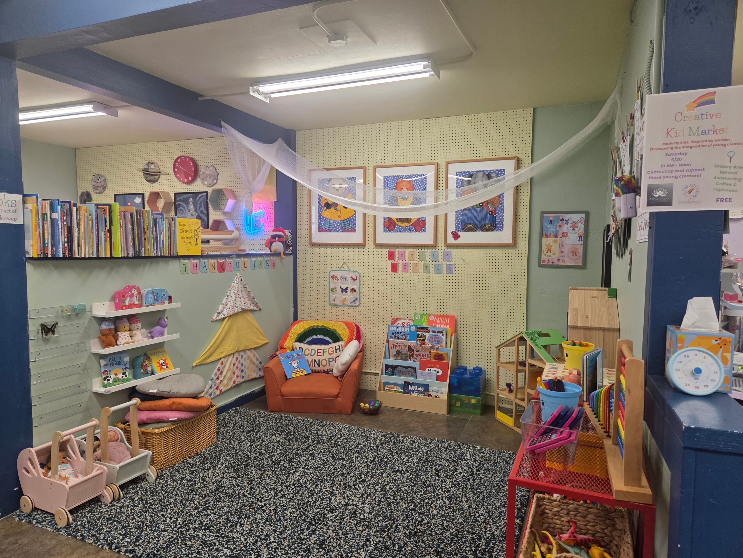 Children's playroom with books, toys, and colorful decorations on light green walls.