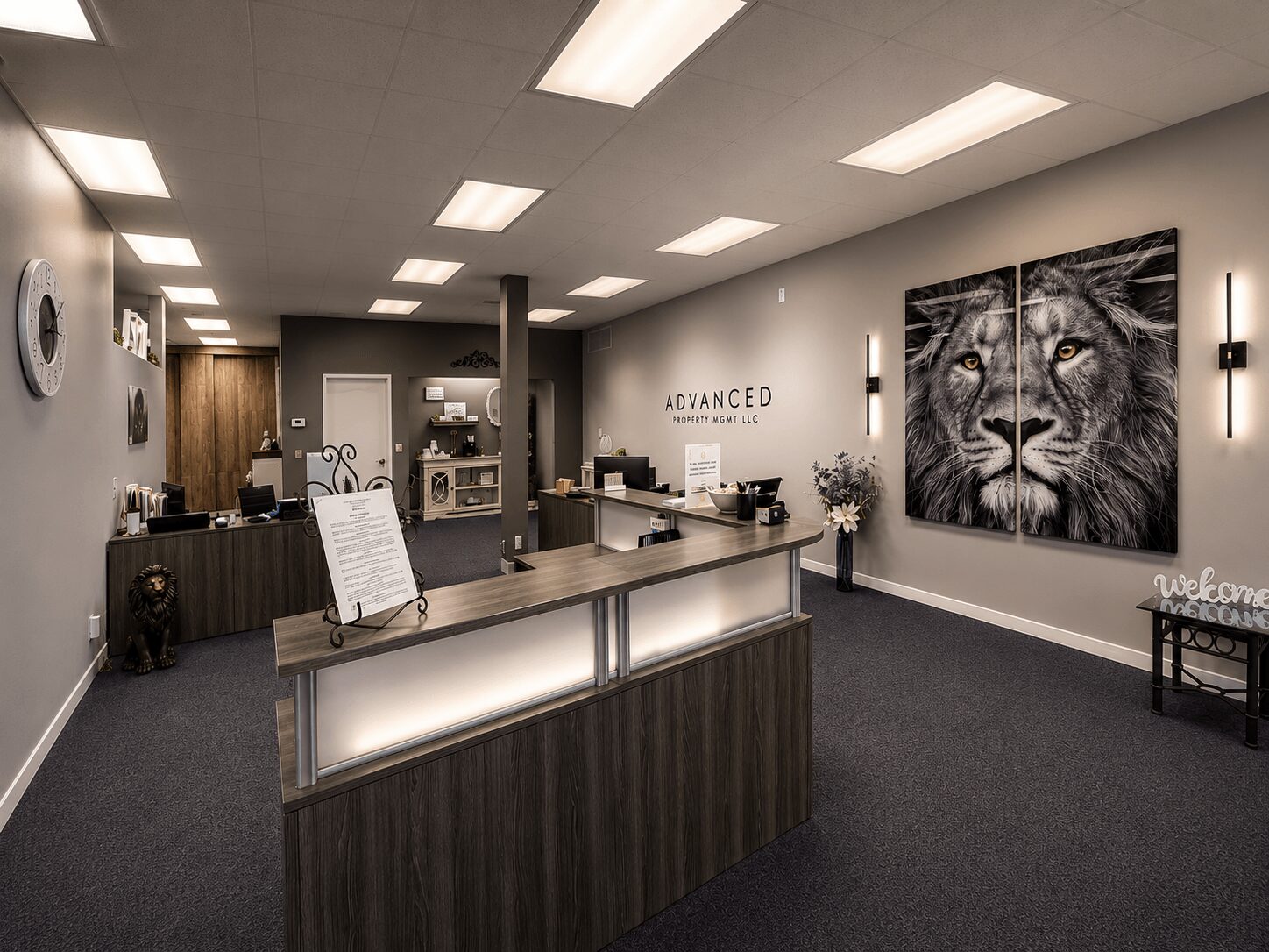 Reception area with a large lion portrait on the wall, a curved desk, and a sign reading 'ADVANCED'.