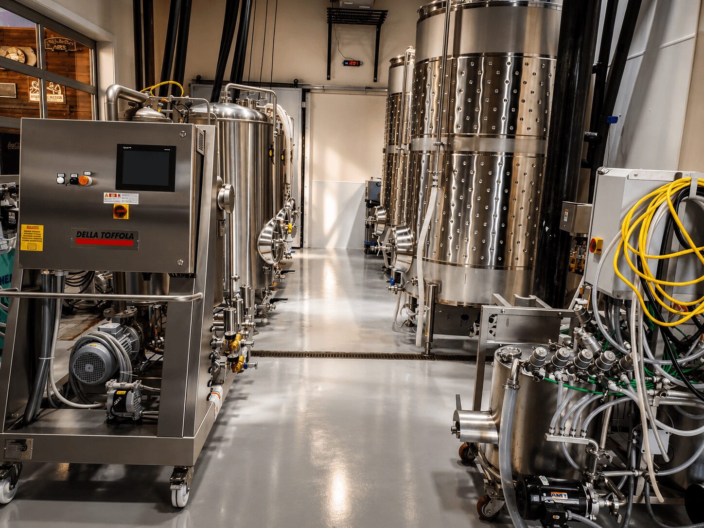 Industrial equipment with stainless steel tanks and control panels in a clean, well-lit facility.