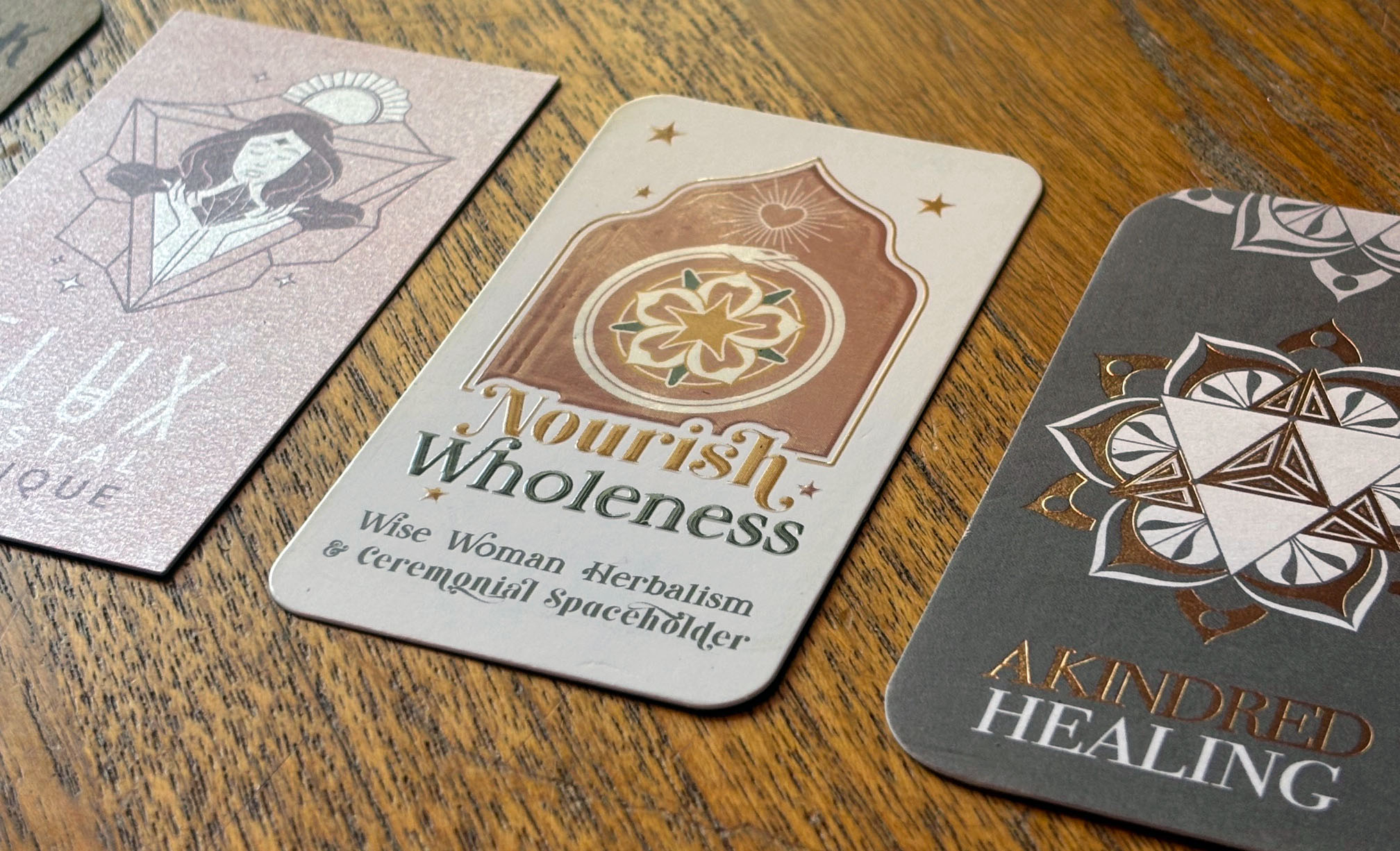 Three cards with mystical symbols and text on a wooden surface, one card reads 