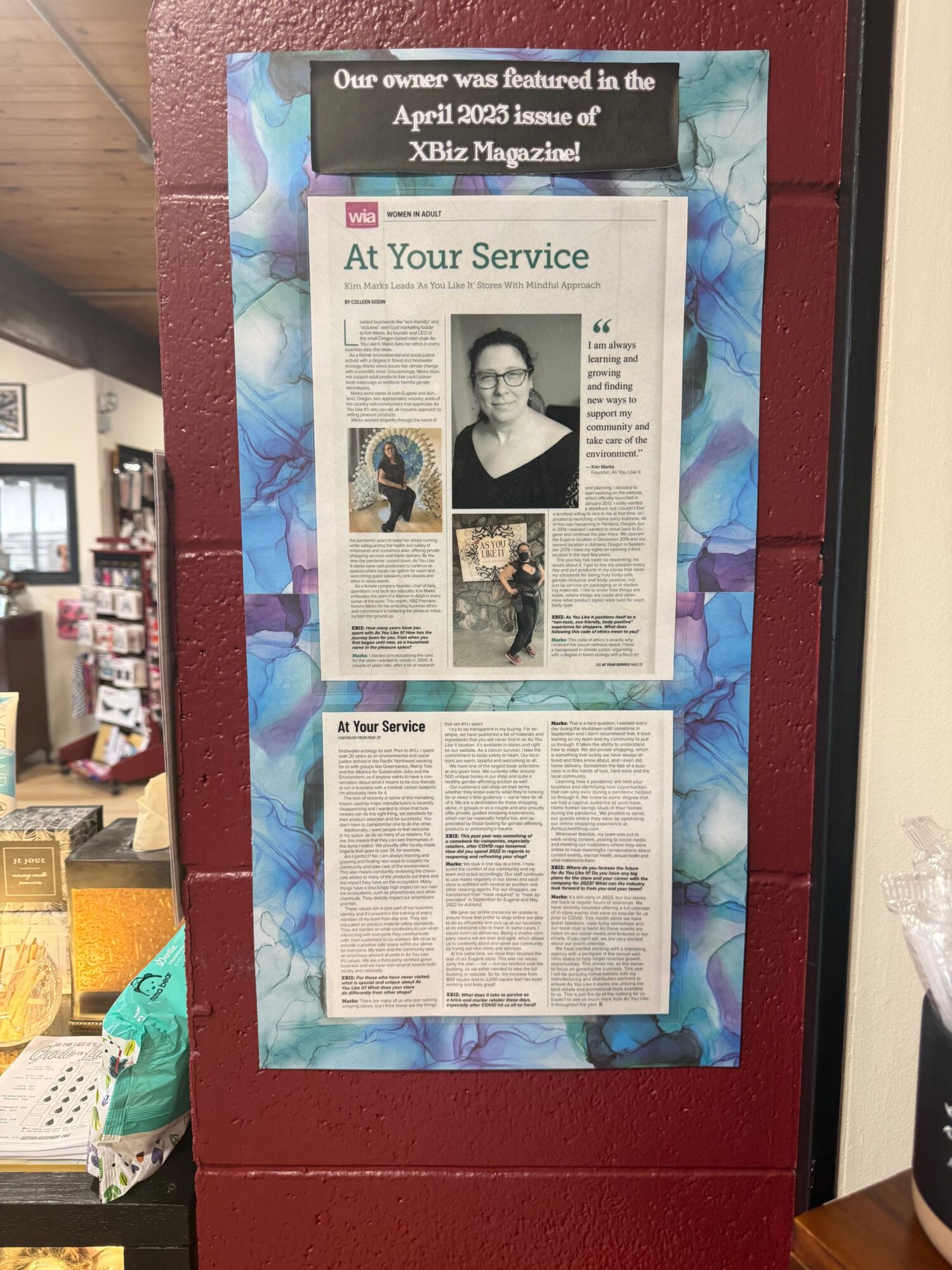 Two newspaper pages displayed on a blue patterned background, with text and images, including a portrait of a person.