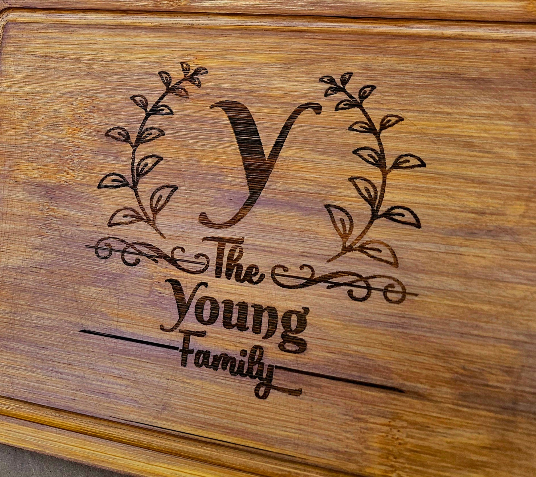 Wooden surface with engraved text and decorative elements, reading