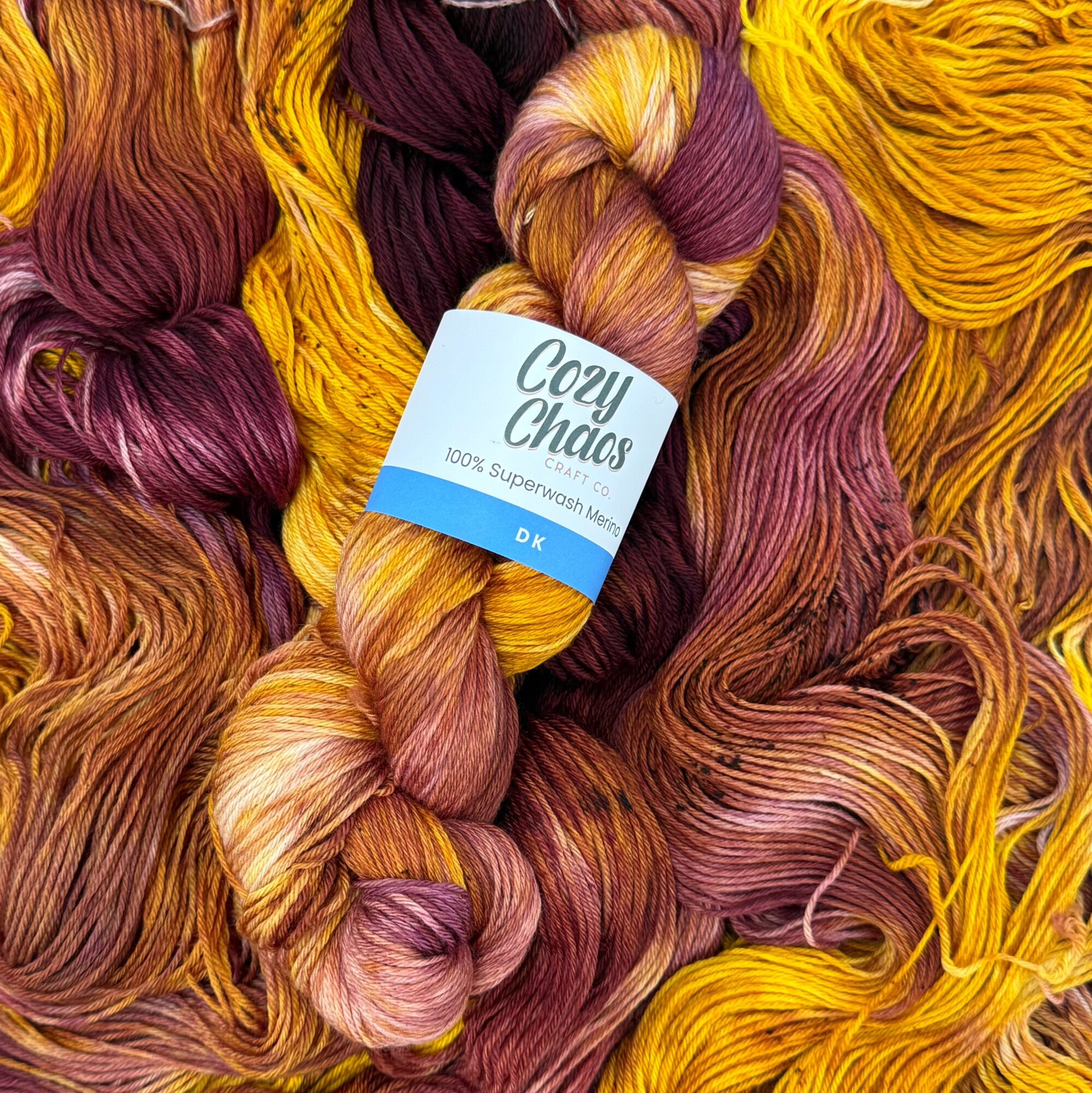 Colorful yarns in shades of purple, pink, orange, and yellow with a label reading 