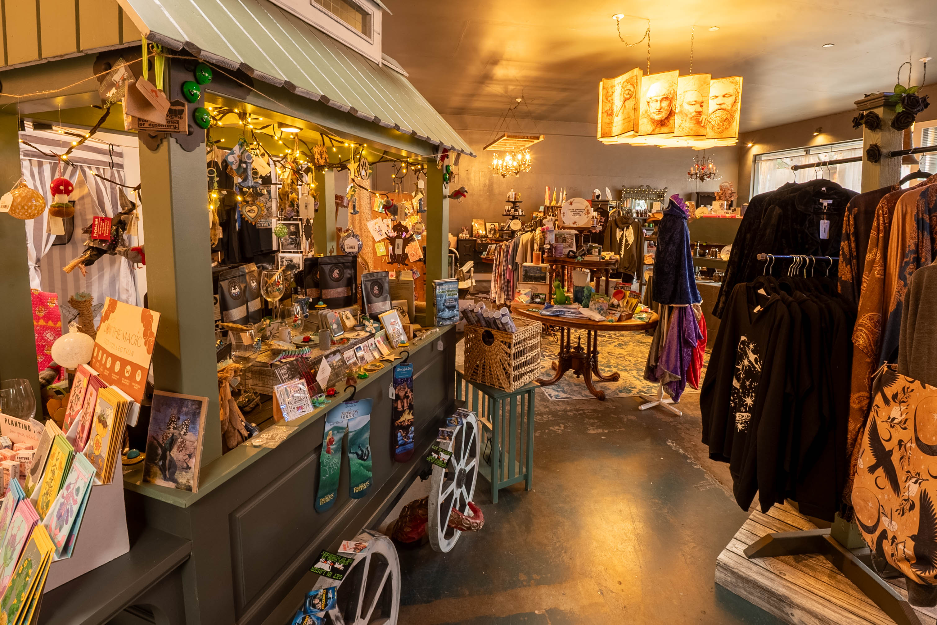 Interior of a boutique store with clothing, accessories, and decorative items displayed on shelves and racks, warm lighting.