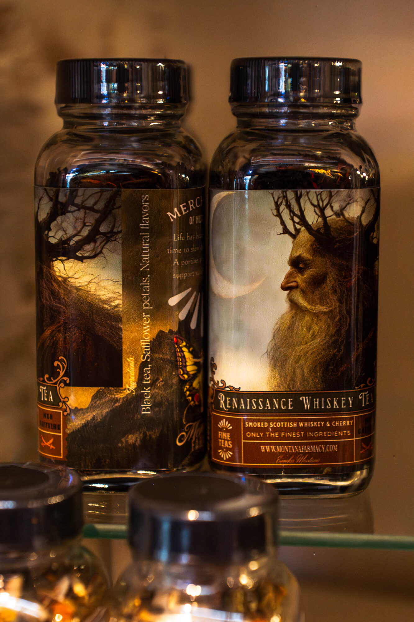 Two bottles with fantasy-themed labels, one featuring a landscape and the other a bearded man with trees and a moon, on a shelf.