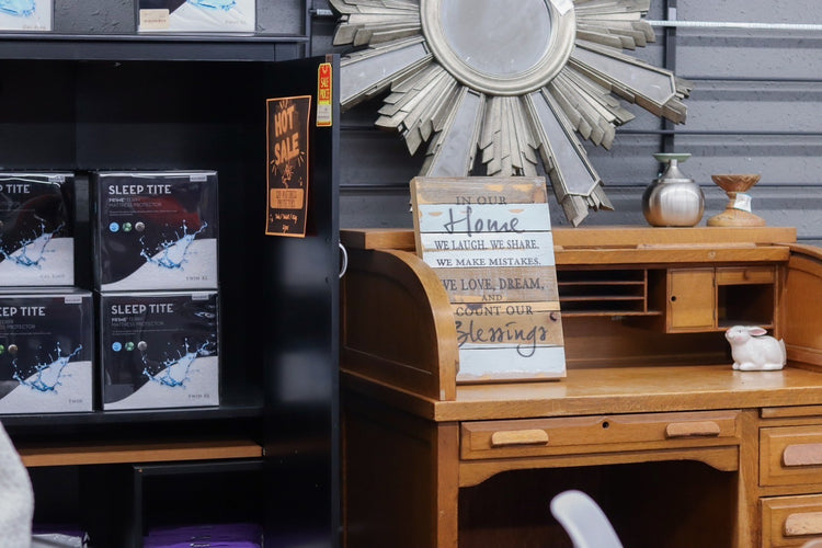 Decorative mirror, wooden desk with sign, and shelves with sleep-related products, in a cozy room.