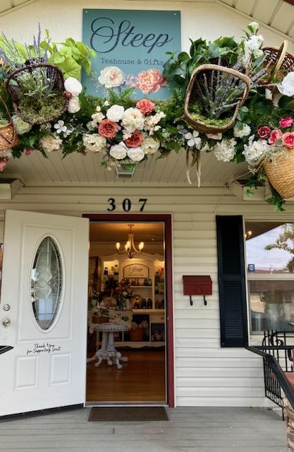 Entrance to a shop with floral decorations above the door, a sign reading 'Sleep,' and the number 307, with an open door revealing the interior.