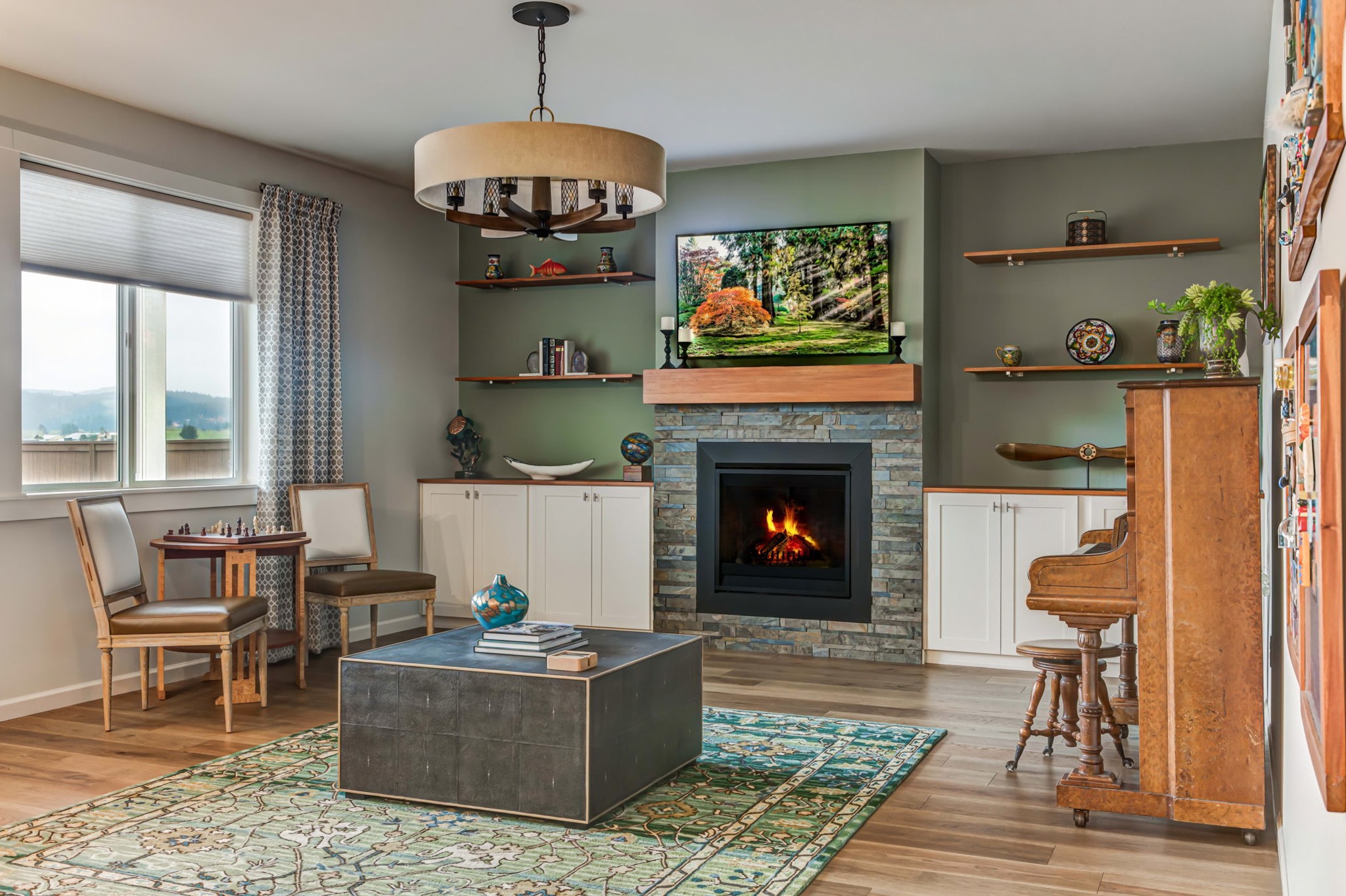 Living room with fireplace, TV, wooden furniture, and a window with curtains, decorated with shelves and a rug.