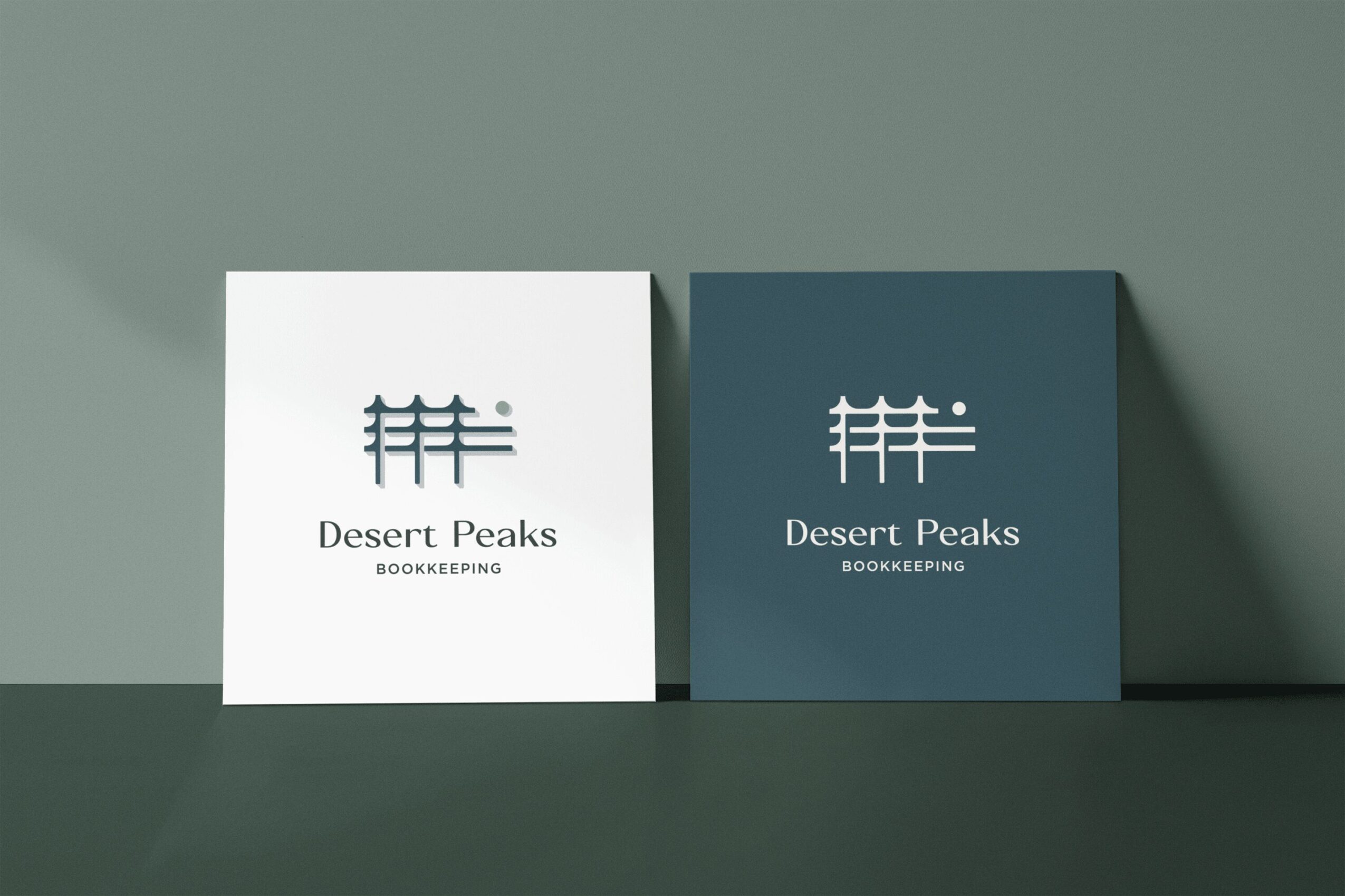 Two square signs with logo and text, one white and one dark blue, placed on a surface against a wall.