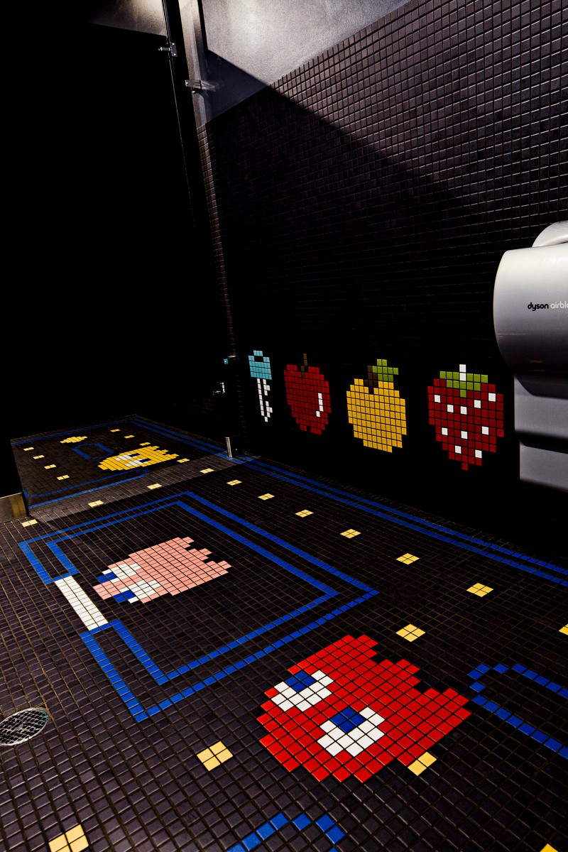 Pixel art of a pig, a red character, and a yellow and red character on a black tiled wall, with pixel art floor.