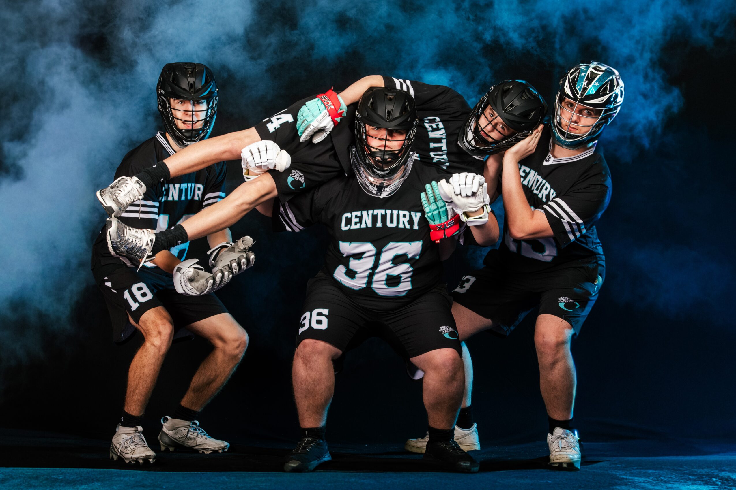 Five roller hockey players in black uniforms pose together, with a smoky background.
