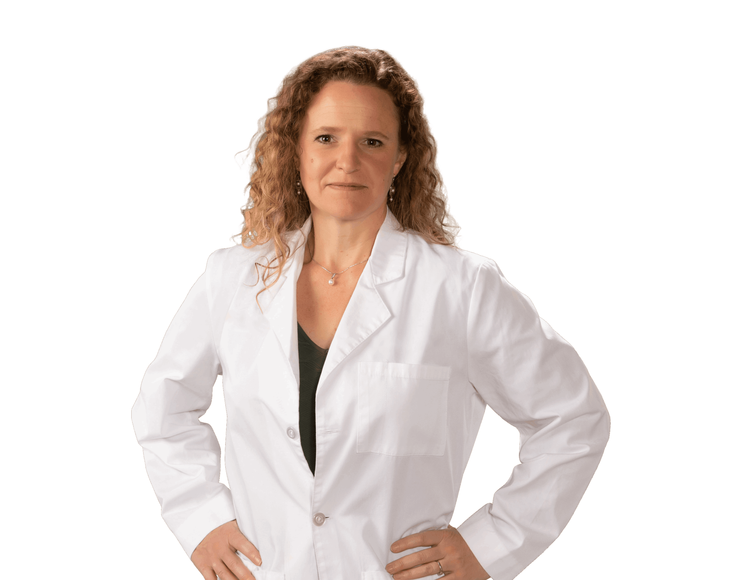 Woman with curly hair wearing a white lab coat, standing with hands on hips against a black background.